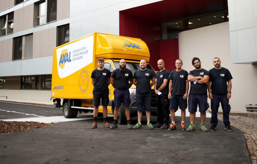 Déménageurs posant devant un camion Axal, entreprise spécialisée en déménagement et logistique